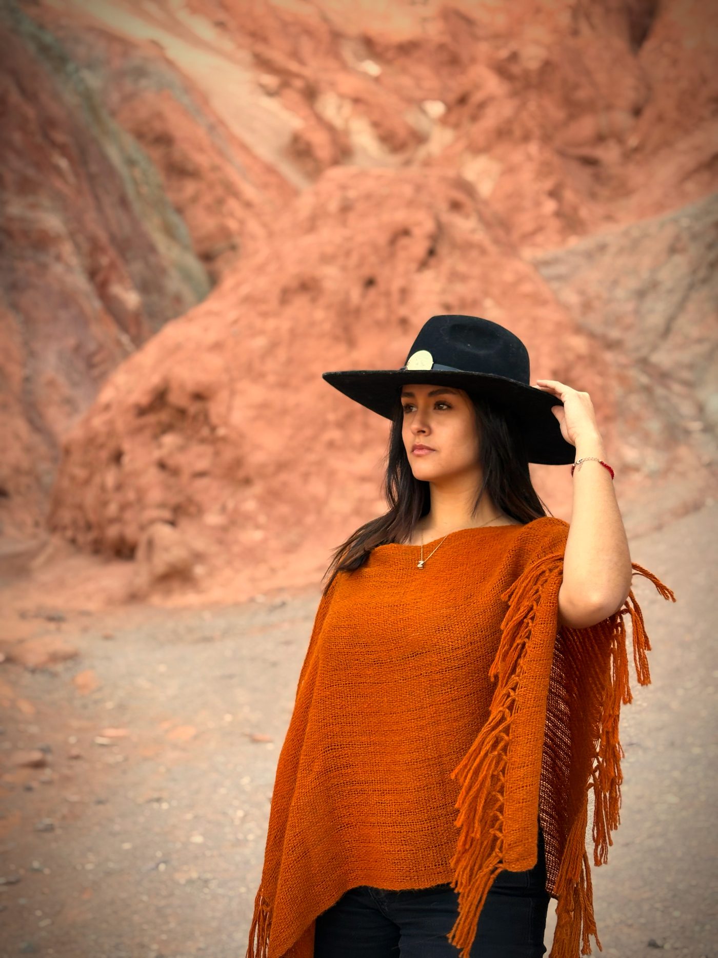 Poncho corto en tono terracota con flecos, fibra de llama, diseño contemporáneo Bella Puna